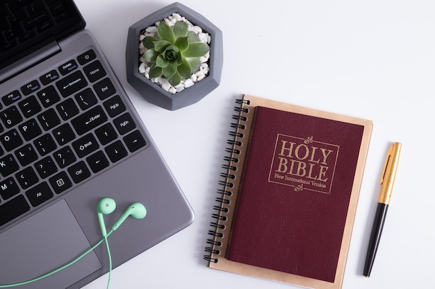 Bible on work desk with laptop and coffee