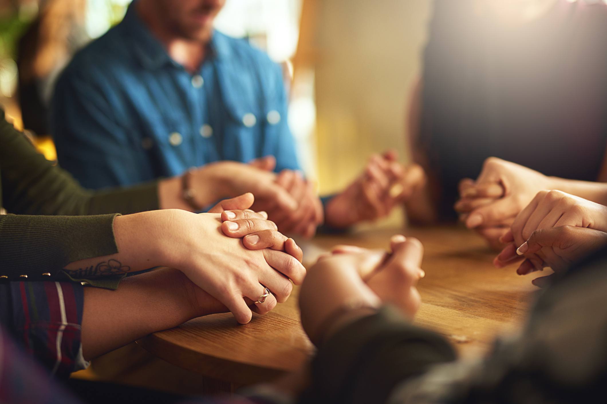 Community holding hands in prayer