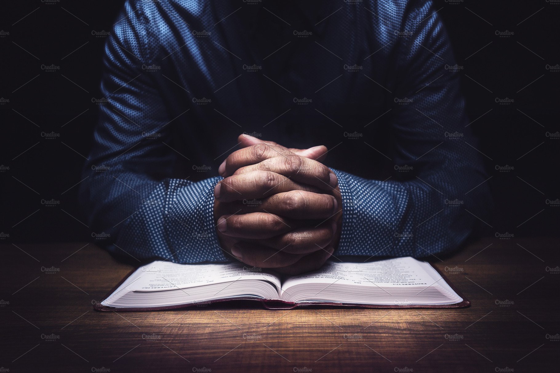 Man praying over work desk