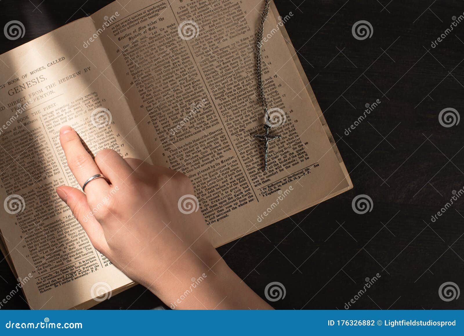 Person reading the Bible near a cross